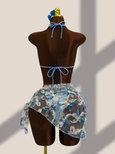 Détail de dos d'un bikini bleu avec broderie florale et paillettes sur jupe en mesh