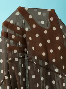 Detailopname van bruine mesh badkledingstof met witte stippen en transparante look