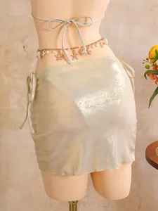 Close-up back view of shimmering gold bikini skirt with seashell charm waist chain