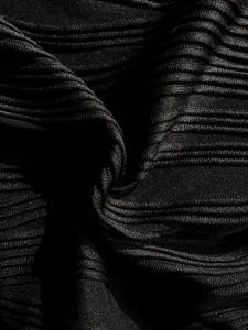Primer plano detallado de la elegante tela negra con textura ondulada de un traje de baño retro.