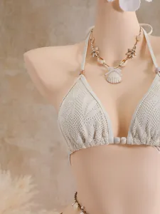 Vue détaillée d'un haut de bikini en dentelle crème élégant avec décorations de coquillages