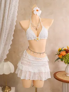 Elegantes weißes Bikini-Set mit Blumenstickerei und passendem Strandrock-Detail.