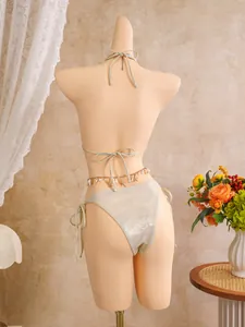 Back view detail of a sexy shiny champagne bikini with a starfish charm waist chain accessory.