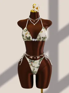 Détails de la broderie florale et des paillettes sur un ensemble bikini en résille crème