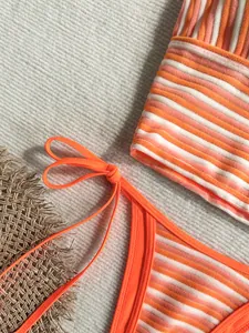 Vista detallada de la textura de rizo y las rayas naranjas de este elegante conjunto de bikini