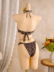 Achteraanzicht van een bruine bikini met stippen en schelpdetails op een etalagepop