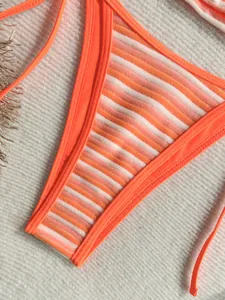Primer plano detallado que muestra la textura de toalla del bikini de rayas naranjas
