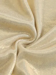 Close-up macro view of shimmering gold metallic fabric with a fine ribbed knit texture