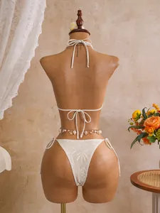 Gedetailleerd achteraanzicht van een witte holle kanten bikiniset voor vakantie