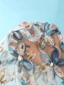 Détail rapproché d'un tissu de bain en résille avec broderies florales et paillettes.
