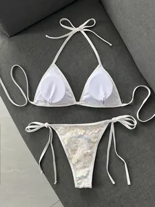 Vista detallada del conjunto de bikini blanco con lentejuelas y aplicaciones de flores 3D.