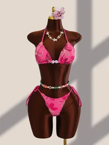 Détail de l'ensemble bikini rose avec broderies florales et paillettes brillantes chic.