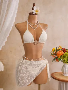 Detail van witte driedelige kant bikini set met haltertop en sarong wikkel