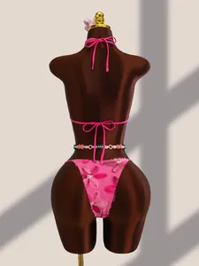 Vue détaillée du bas de bikini en résille rose avec broderies florales et paillettes sur mannequin