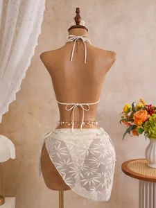 Achteraanzicht van een witte driedelige gehaakte bikiniset met zeester tailleketting.
