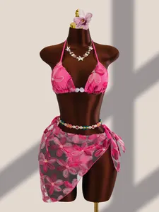 Vue détaillée de la broderie florale rose et des paillettes sur un ensemble bikini