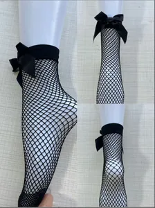 Detailed view of black fishnet ankle socks featuring a decorative satin bow on a mannequin leg