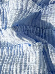 Gros plan détaillé sur la texture du tissu bleu plissé de maillot de bain aux reflets étoilés