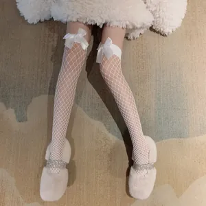 Close-up detail showing the intricate white fishnet pattern and satin bow of these stockings