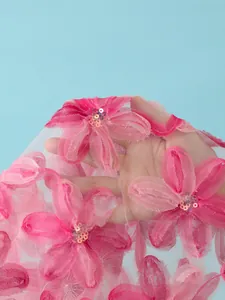 Gros plan détaillé du tissu en maille rose avec broderie florale et sequins brillants