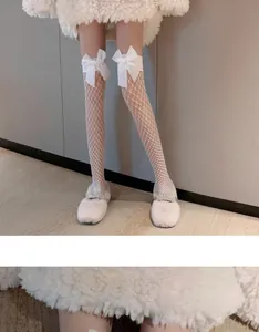 Detailed view of white fishnet over-the-knee socks featuring delicate white bows and mesh texture