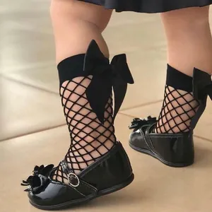 Toddler girl's stylish black fishnet mid-calf socks featuring an elegant ribbon bow
