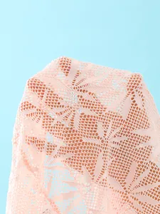 Macro-weergave van delicate roze gehaakte kantstof voor zomerse strandrok cover-up