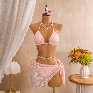 Elegant lichtroze driedelig opengewerkt bikinisetje met bijpassende mini sarongrok.