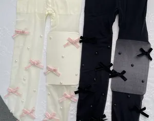 Nahaufnahme von süßen Lolita-Strumpfhosen mit Samtschleifen und Perlenverzierungen