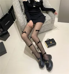 Schwarze transparente Strumpfhosen mit Schleifen und Perlen in einer Lifestyle-Umgebung