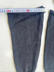 Ausmessen der Breite von schwarzen gestrickten Beinstulpen im Lolita JK Stil.