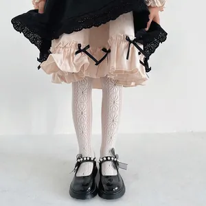 Detailed close-up of girls floral patterned lace tights in white princess style