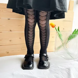 Close-up of girl's black mesh tights featuring a cute knitted heart pattern design