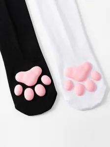 Close-up detail of 3D pink silicone cat paw pads on black and white Japanese style over-knee socks