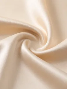 Close-up view of beige velvet fabric showing smooth texture and high elasticity.