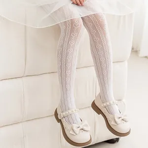 Detailed view of girl's white heart pattern mesh tights featuring delicate lace texture