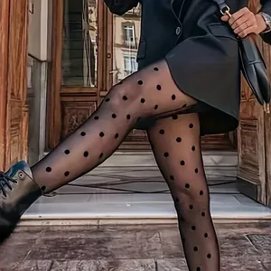 Elegant black polka dot sheer tights shown in a fashionable street style outfit