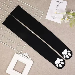 Detailed view of black over-the-knee socks with white 3D silicone cat paw pads.