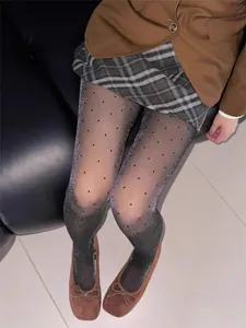 Close-up of elegant black polka dot tights with subtle silver shimmer and glitter finish