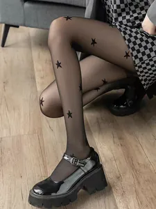 Detail view of black sheer pantyhose with stylish star patterns paired with platform shoes