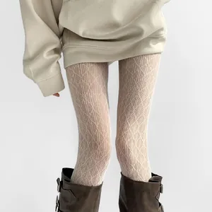 Detailed macro view of white hollow-out lace tights featuring a classic diamond mesh pattern
