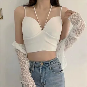 Nahaufnahme eines weißen Neckholder-Crop-Tops mit elegantem Spitzen-Bolero und Jeans