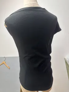 Close-up back view of black slim fit ribbed T-shirt with gold ring sleeve detail