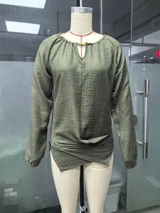 Detailaufnahme des grünen Langarmshirts mit unregelmäßigem Saum und Bindedetails