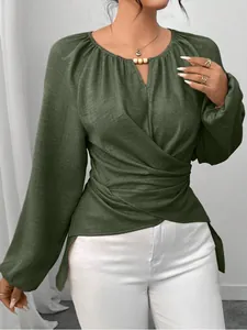 Detailansicht einer olivgrünen Damen-Wickelbluse mit langen Ärmeln und asymmetrischem Saum.