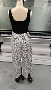 Back view of sleeveless polka dot wide-leg jumpsuit on mannequin in workshop.