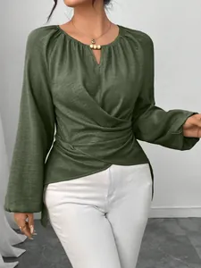 Detailansicht der olivgrünen Wickelbluse mit Bindegürtel und asymmetrischem Saum