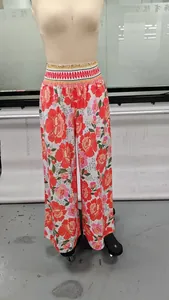 Détail d'un pantalon large à fleurs pour femme avec taille haute sur un mannequin.