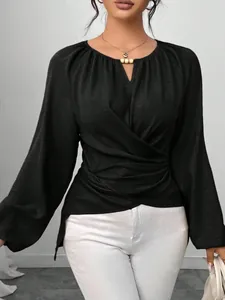 Elegantes schwarzes Langarm-Oberteil mit Wickeltaille und unregelmäßigem Saumdesign.