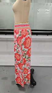 Vue détaillée d'un pantalon large à taille haute avec imprimé floral vif sur mannequin.